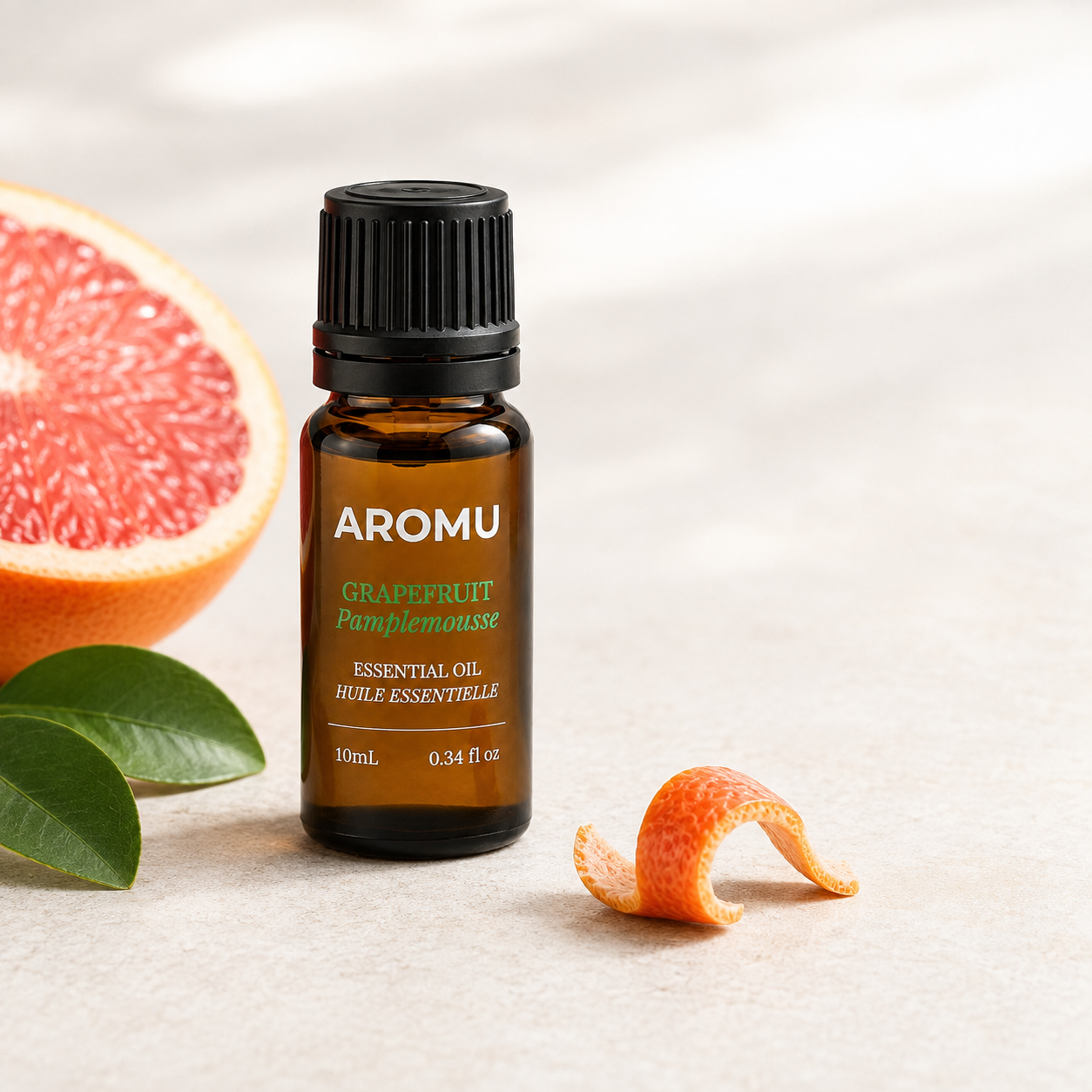 Grapefruit Essential Oil with fresh pink grapefruit and citrus leaves